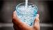 A hand can be seen holding a glass of water