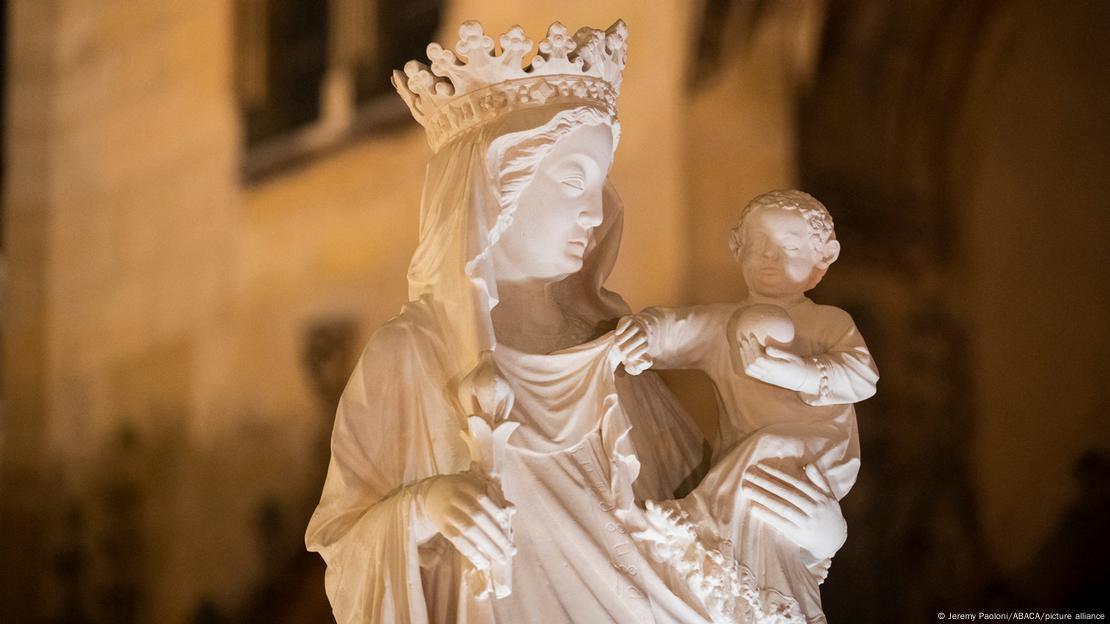 Virgen en mármol blanco y corona en la cabeza, con su hijo en brazos.