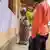 Voters look at voting lists attached to a wall outdoors in Tanzania