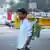 A protester wears a breathing mask connected to a container filled with plants on his back in New Delhi