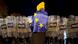 Manifestante envolto em bandeira da União Europeia diante de uma fileira de policiais Manifestante envolto em bandeira da União Europeia diante de uma fileira de policiais