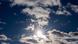 Die Sonne scheint an einem blauen zwischen Wolken hindurch Die Sonne scheint an einem blauen zwischen Wolken hindurch