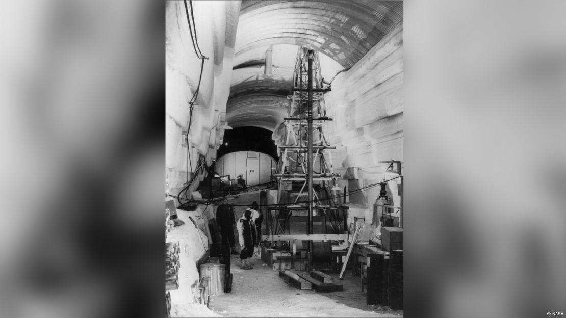 En esta imagen de 1966, en el interior de la base, un taladro térmico es utilizado junto con el taladro eléctrico desarrollado posteriormente en el programa de perforación profunda del Laboratorio de Investigación e Ingeniería de Regiones Frías del Ejército de los EE. UU. En esta imagen de 1966, en el interior de la base, un taladro térmico es utilizado junto con el taladro eléctrico desarrollado posteriormente en el programa de perforación profunda del Laboratorio de Investigación e Ingeniería de Regiones Frías del Ejército de los EE. UU.