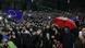 Una bandera de la Unión Europea ondea sobre una multitud de manifestantes. Una bandera de la Unión Europea ondea sobre una multitud de manifestantes.