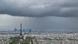 Foto panorâmica de Paris, com vários prédios, e destaque para a Torre Eiffel. O dia está nublado, com muitas nuvens escuras e chuva. Foto panorâmica de Paris, com vários prédios, e destaque para a Torre Eiffel. O dia está nublado, com muitas nuvens escuras e chuva.