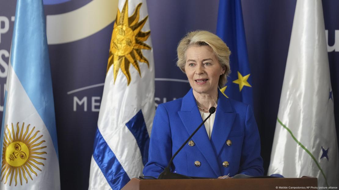 EU-Kommissionspräsidentin Ursula von der Leyen spricht auf dem Mercosur-Gipfel 2024 in Mexiko vor den Flaggen Argentiniens, Uruguays und der EU