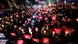 A crowd of protesters in Seoul holding red signs and hand-held lights A crowd of protesters in Seoul holding red signs and hand-held lights