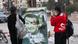 Mulher tira uma foto de um retrato destruído de Assad em Qamishli