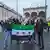 Syrians holding a revolutionary flag with the word "freedom" on Munich's Odeonsplatz