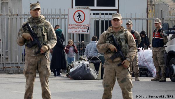 Türkiye'nin Suriye sınırında elinde silahlarla güvenliği sağlamaya çalışan iki asker Türkiye'nin Suriye sınırında elinde silahlarla güvenliği sağlamaya çalışan iki asker