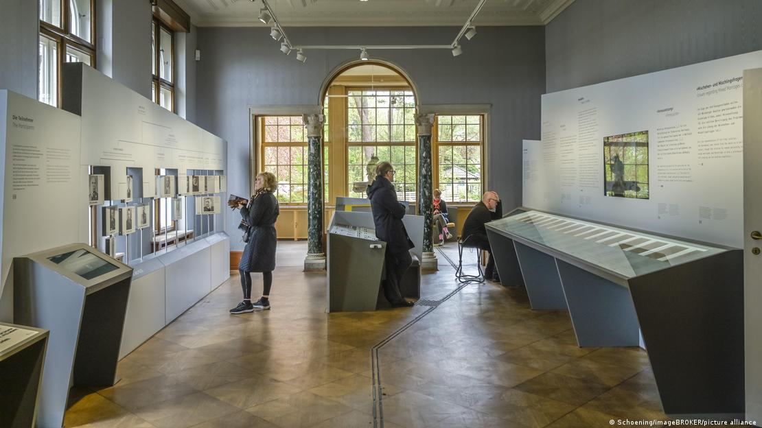 Un grupo de personas en una sala de la Casa de la Conferencia de Wannsee.