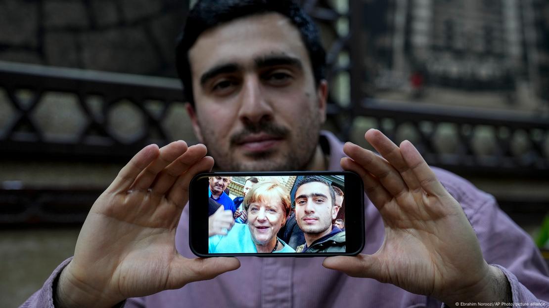 Anas Modamani, refugiado sirio en Alemania, muestra su famoso selfie con la canciller alemana Angela Merkel que se tomó tras llegar al país.