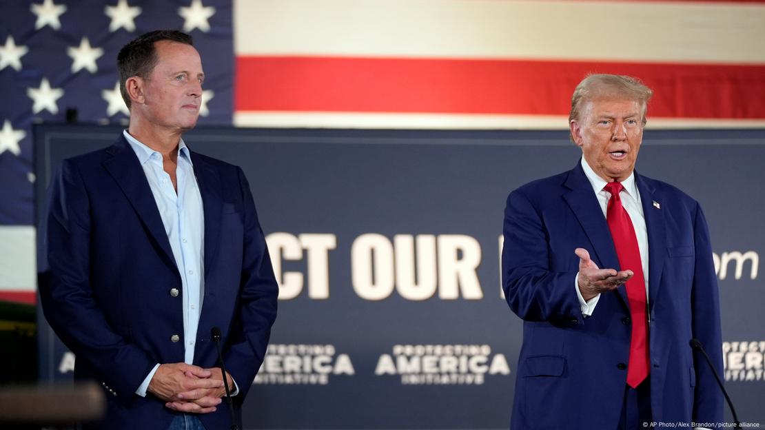 Richard Grenell, Pensilvanya'daki bir etkinlikte sahnede yanında konuşan Donald Trump'ı dinliyor. İki isim de ayakta duruyor