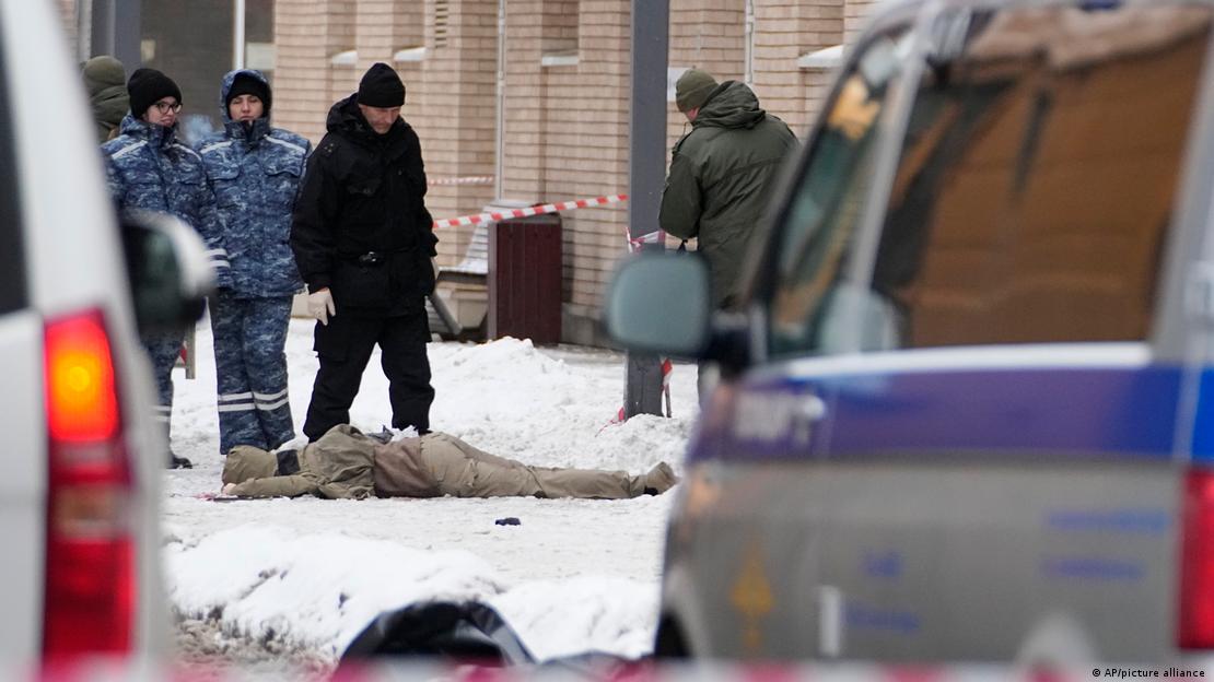 Investigadores russos observam corpo caído no local da explosão