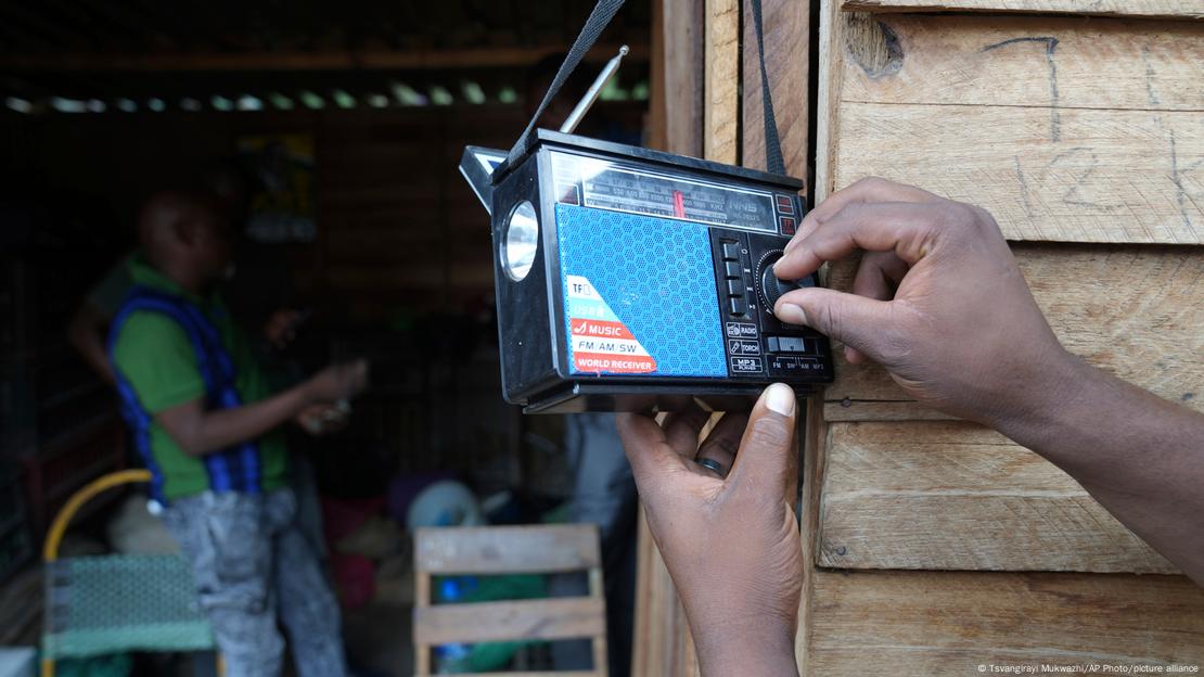 Un mano maneja el dial de una radio de onda corta en Zimbabue. Un mano maneja el dial de una radio de onda corta en Zimbabue.