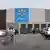 Facade of a Walmart store in Chicago, United States, with a parking lot with seven cars and two customers with shopping carts as well as plants for sale