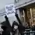 A protester holds a placard outside a US district court, on the day Luigi M., the suspect in the murder of UnitedHealth Group executive Brian Thompson, consented to surrender to the New York police officers and to be extradited from Pennsylvania