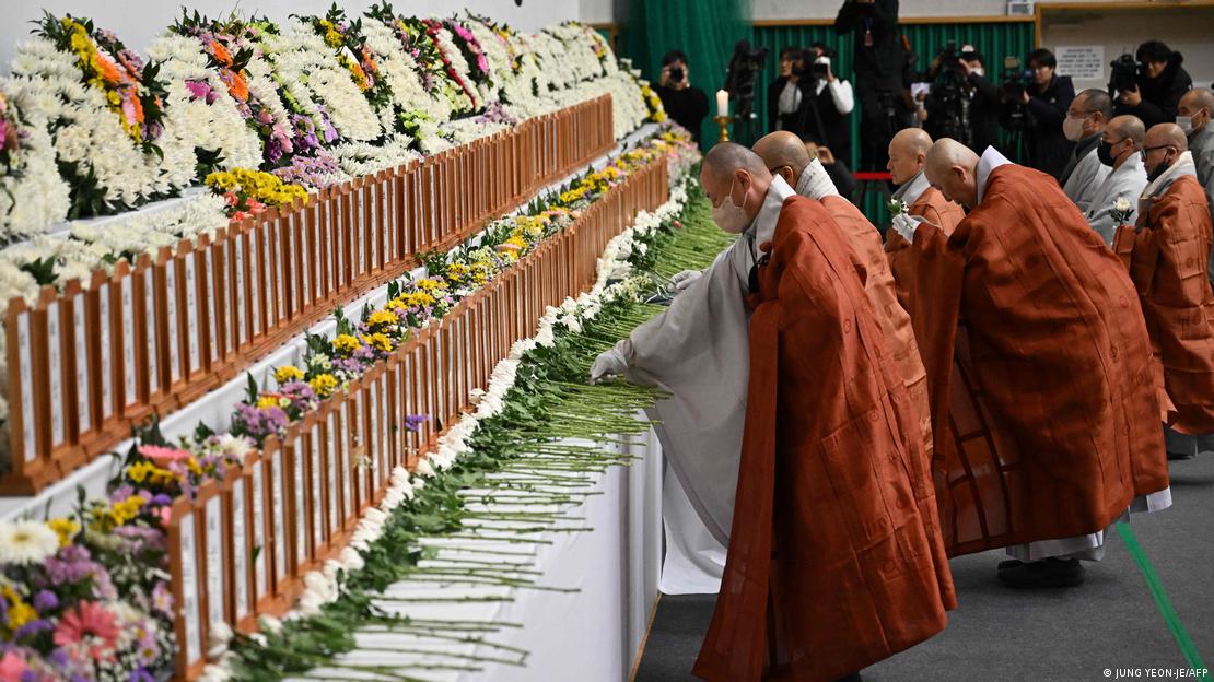 Sacerdotes deixam flores em memorial para vítimas Sacerdotes deixam flores em memorial para vítimas