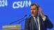 Bavaria's State Premier Markus Söder speaking at a lectern with his left hand raised Bavaria's State Premier Markus Söder speaking at a lectern with his left hand raised