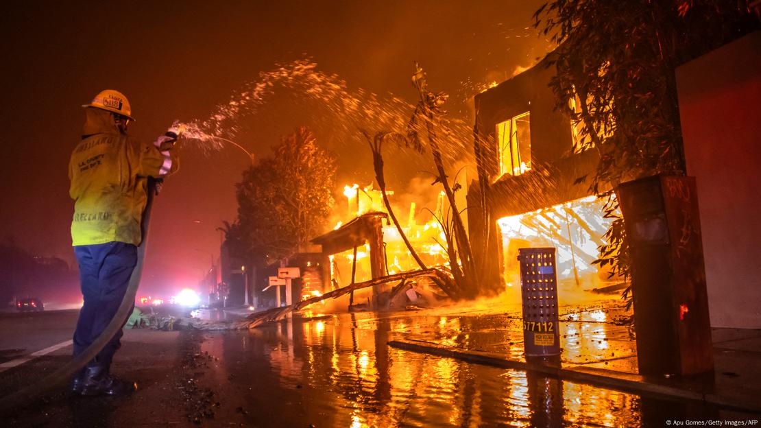 A firefighter battles the Palisades Fire as it burns homes in Los Angeles on January 8, 2025 