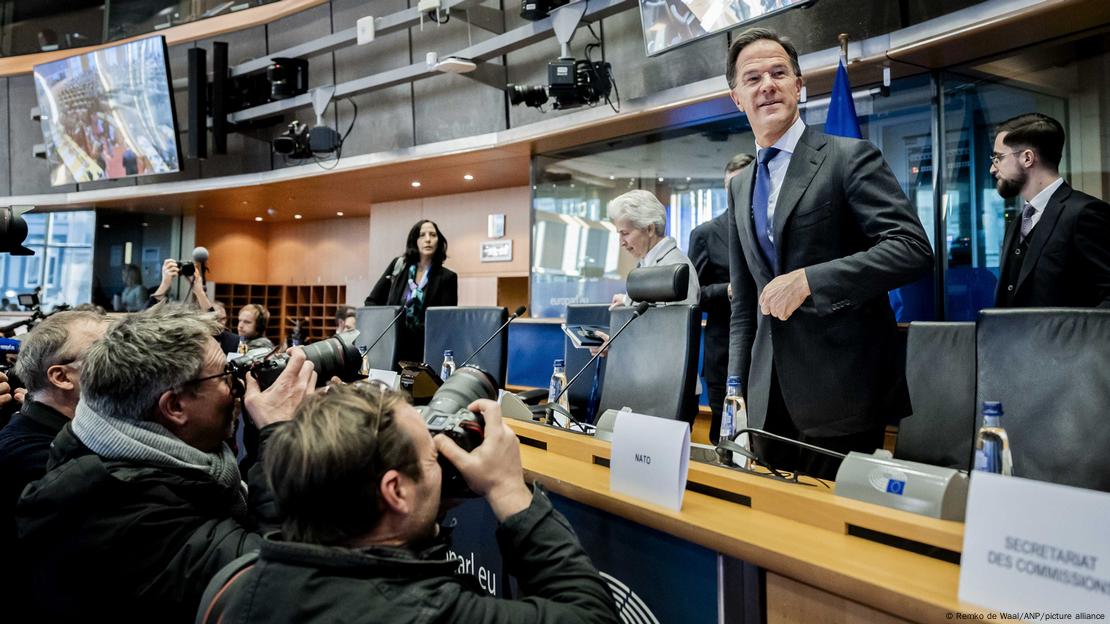 Mark Rutte në këmbë para tij fotografët me kamera