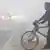 A rickshaw cart puller on a foggy street in New Delhi