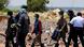 Illegal miners are escorted by police officers after being rescued from an abandoned gold mine Illegal miners are escorted by police officers after being rescued from an abandoned gold mine