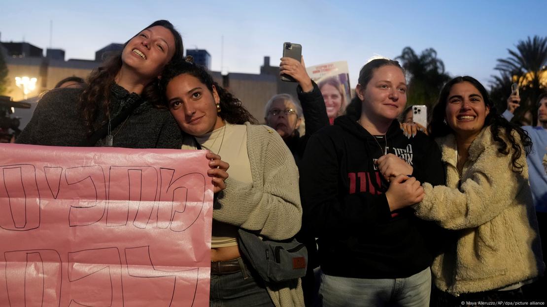Familiares e amigos dos reféns israelenses seguram cartazes e se abraçam