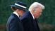 Melania, wearing suit and wide-brimmed hat, walks alongside husband Donald Trump Melania, wearing suit and wide-brimmed hat, walks alongside husband Donald Trump