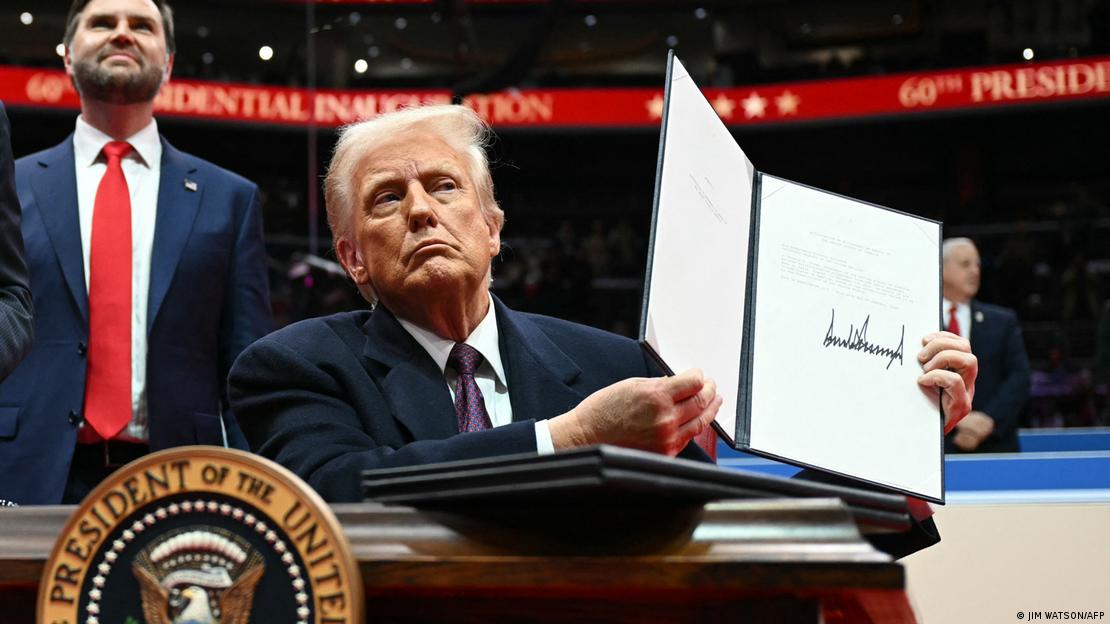 Presidente dos EUA, Donald Trump, exibe sua assinatura em ordem executiva que retirou seu país do Acordo de Paris. Logo atrás dele, em pé, está seu vice J.D. Vance, sorrindo