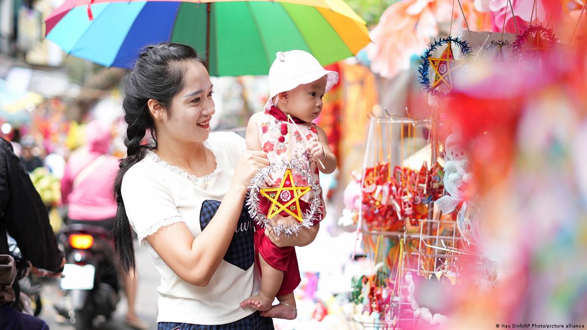 A woman carries a baby holding a star lantern for the Mid-Autumn Festival, or Moon Festival, in Hanoi, Vietnam Tuesday, September 17, 2024
