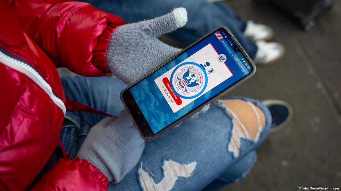 Uma migrante segura um telefone celular contendo o aplicativo CBP One, instituído pelo governo Biden e por meio do qual era possível agendar pedidos de asilo nos Estados Unidos. Uma migrante segura um telefone celular contendo o aplicativo CBP One, instituído pelo governo Biden e por meio do qual era possível agendar pedidos de asilo nos Estados Unidos.