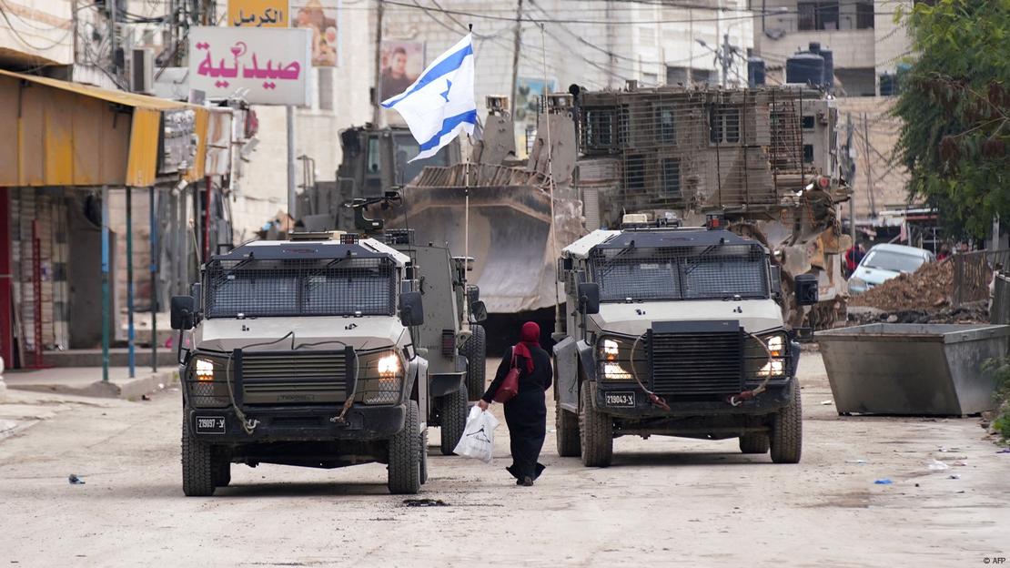 Vehículos militares portando una bandera israei en Yenín.