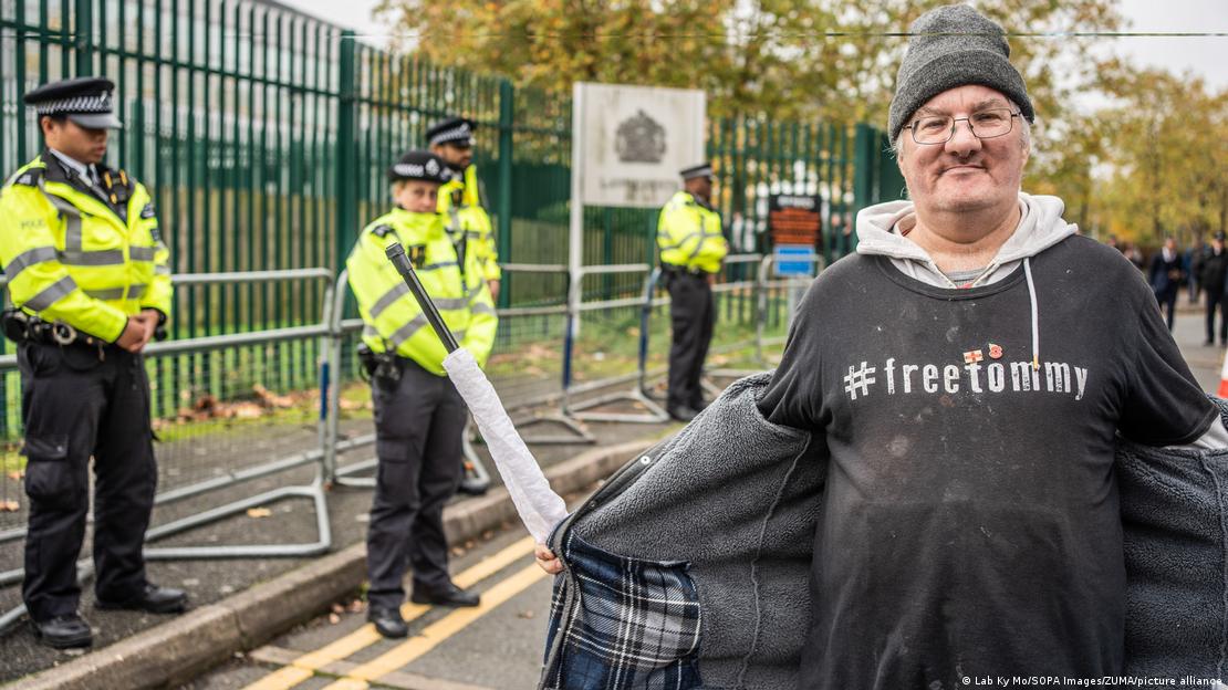 Ein Mann zeigt sein T-Shirt mit der Aufschrift #freetommy