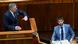 Slovakia's Prime Minister Robert Fico (left) can be seen making large gestures with both hands at the speakers' podium in the Slovak parliament. He is turning to look at Michal Simecka (right), leader of the opposition Progressive Slovakia party leader, who is seated at a desk and looking straight ahead with a very serious expression on his face. Bratislava, Slovakia, January 21, 2025