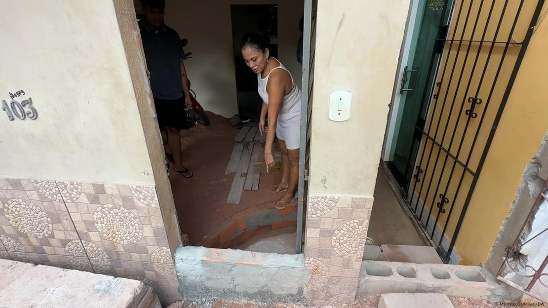 Mulher mostra a barreira que construiu na entrada da sua casa com objetivo de evitar alagamentos na época de chuvas em Belém