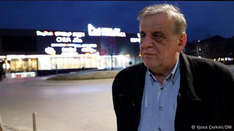 Nexhmedin Saphiu fotografuar në qytet, me xhaketë të errët dhe këmishë bojëqielli Nexhmedin Saphiu fotografuar në qytet, me xhaketë të errët dhe këmishë bojëqielli