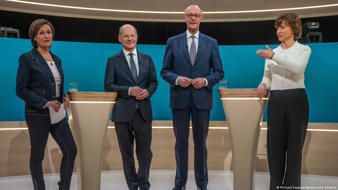 Dy politikanët Olaf Scholz dhe Friedrich Merz bashkë me moderatoret Maybrit Illner dhe Sandra Maischberger në këmbë në studion televizive para fillimit të debatit televiziv Dy politikanët Olaf Scholz dhe Friedrich Merz bashkë me moderatoret Maybrit Illner dhe Sandra Maischberger në këmbë në studion televizive para fillimit të debatit televiziv