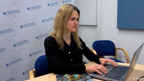 mujer sentada de perfil en su escritorio escribe en computadora. mujer sentada de perfil en su escritorio escribe en computadora.