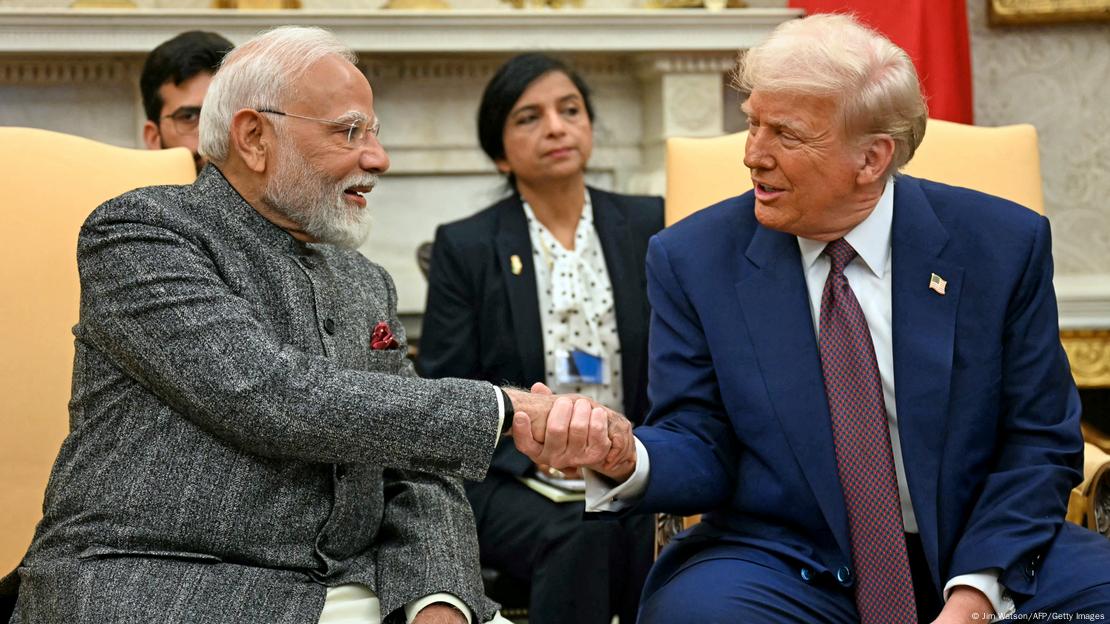 Trump e Modi, sentados, em aperto de mãos