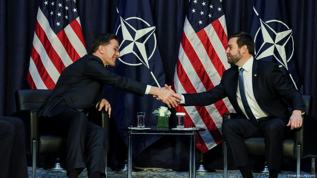 NATO Genel Sekreteri Mark Rutte ile ABD Başkan Yardımcısı JD Vance, ABD ve NATO bayrakları önünde oturur halde tokalaşıyor