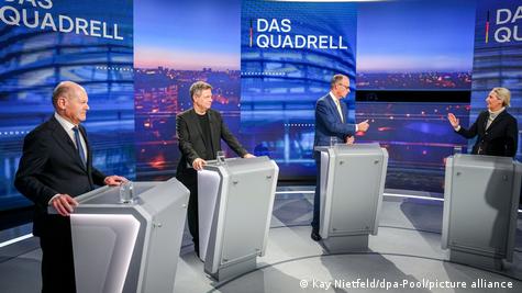 Scholz, Habeck, Merz dhe Weidel në një studio televizive në këmbë. Secili ka përpara një pult. Merz debaton me Weidel Scholz, Habeck, Merz dhe Weidel në një studio televizive në këmbë. Secili ka përpara një pult. Merz debaton me Weidel