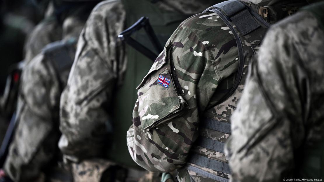The arms and torsos of several uniformed British soldiers 