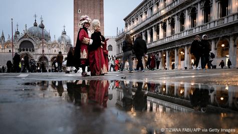 Pamje nga sheshi San Marco i Venecias me karnavalet dhe sigurën e Casanovës me një zonjë për krahu Pamje nga sheshi San Marco i Venecias me karnavalet dhe sigurën e Casanovës me një zonjë për krahu