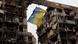 A tattered Ukrainian flag hangs on a wire in front of a destroyed apartment building in Mariupol, Ukraine A tattered Ukrainian flag hangs on a wire in front of a destroyed apartment building in Mariupol, Ukraine