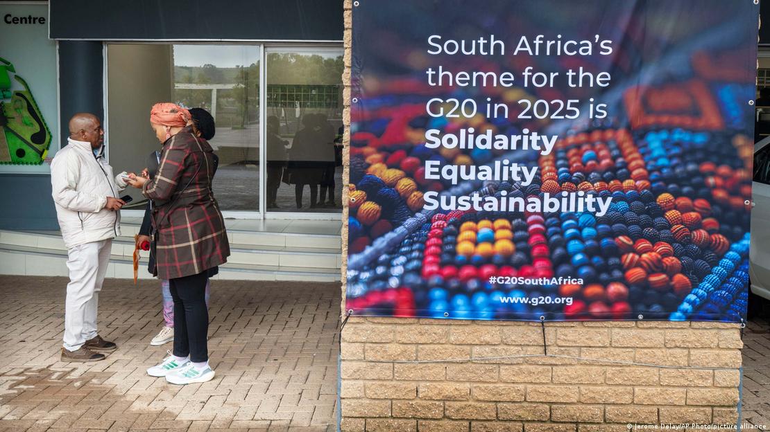 Südafrika Johannesburg 2025 | Gruppe von Afrikaner stehen neben einem Plakat mit dem G20 Motto Solidarität, Gleichheit, Nachhaltigkeit