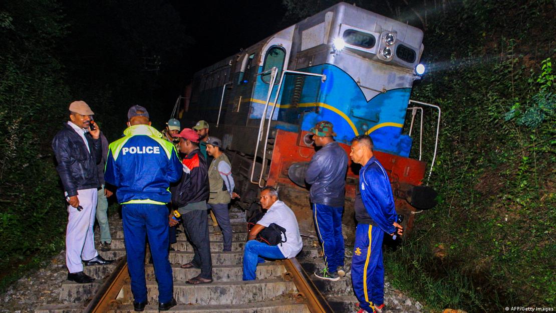 Sri Lanka, Habarana, 2025 | Policía y otras personas junto a un tren desacarrilado antes del amanecer. Sri Lanka, Habarana, 2025 | Policía y otras personas junto a un tren desacarrilado antes del amanecer.