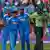 Indian bowlers in the background look on as a Pakistani batsman walks off the field