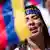Rostro de mujer con ojos cerrados y una cinta en la cabeza que pone "Venezuela" y una bandera de Venezuela pintada en la cara.