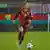 Giulia Gwinn dribbles the ball during a match against Austria, wearing a red kit and rainbow captain's armband